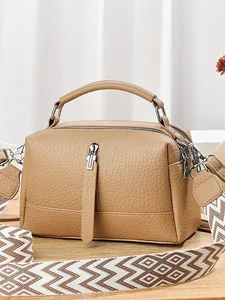 Chic camel leather pillow bag with textured finish and patterned crossbody strap