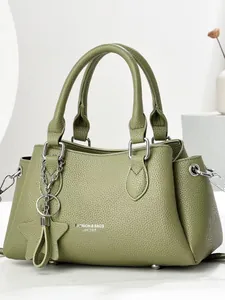 Olive green pebbled leather tote bag with top handles and star tassel charm detail