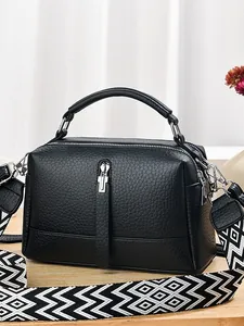 Black pebbled leather pillow bag with silver hardware and geometric patterned wide strap