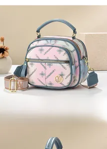 Close-up of pink gradient floral handbag with jacquard strap and metal logo