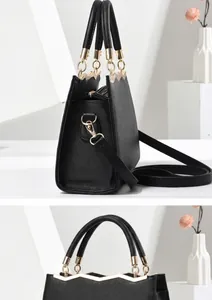 Side view of black Saffiano leather tote showing trapezoid structure and gold hardware