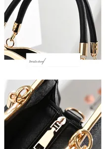 Detail view of black crossgrain leather handbag with round handles and gold hardware