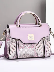 Lavender purple handbag with traditional embroidery and gold bird logo in side view