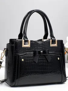 Fashionable black crocodile embossed handbag with glossy patent leather finish and bow