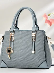 Elegant grey-blue woven handbag with gold clover charm and white pearl detail