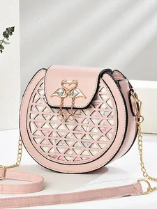 Pink round chain crossbody bag with floral cutouts and golden swan heart metal clasp