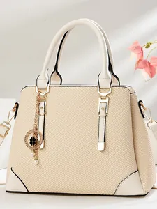 Elegant beige woven textured tote bag with clover charm and adjustable strap