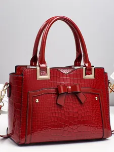 Glossy red crocodile embossed handbag for women with bow decoration and gold handles