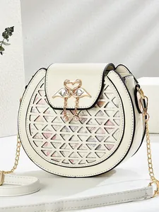 Cream round chain bag with floral laser-cut design and golden swan heart buckle