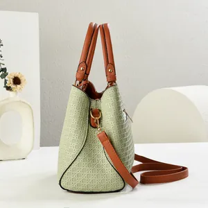 Detail view of woven geometric texture on green faux leather bag with brown straps