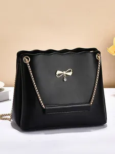 Minimalist black PU leather shoulder bag with gold bow decoration and chain strap