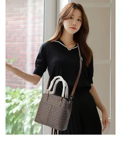 Woman carrying a brown vintage bucket bag with geometric patterns in a bright room