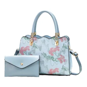 Light blue handbag and wallet set with floral embroidery and wavy edge details