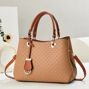Detail of caramel brown woven texture shoulder bag with gold metal buckle and leather handle