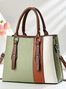 Women's tri-color tote bag in green and brown leather with soft sunlight shadow