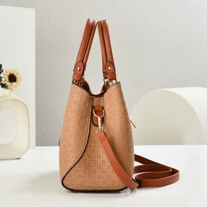 Detail shot of light brown woven texture shoulder bag with premium golden metal accents
