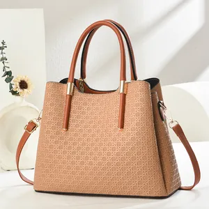 Close-up of earth-tone handbag with geometric woven texture and gold metal hardware