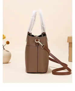 Side view of brown pebbled leather bucket bag featuring gold hardware and strap details
