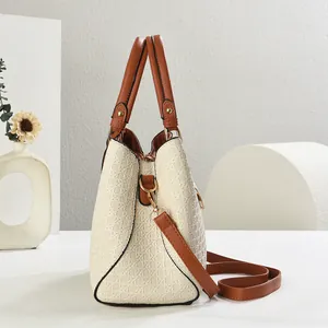 Detailed macro view of beige woven texture with brown leather straps and gold hardware