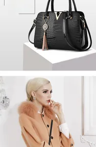 Detail of black crocodile texture tote bag with gold V hardware and elegant tassel detail