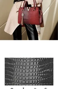 Detail of dark red crocodile pattern PU leather with V-shaped metal hardware and tassel