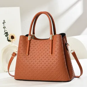 Detail showing woven texture and gold hardware on brown large capacity tote bag