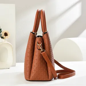 Macro shot of brown leather tote bag with geometric woven texture and gold hardware