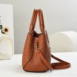 Detail of brown woven texture PU leather handbag with elegant gold hardware and dual handles