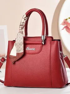 Elegant red litchi grain leather tote bag with silk scarf and silver logo on beige background