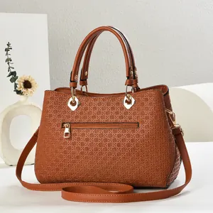 Detail of brown woven texture handbag with golden zippers and detachable strap