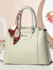 Pale green pebble leather handbag with decorative silk scarf and detachable shoulder strap