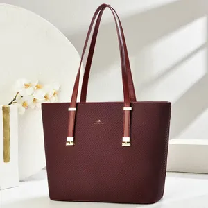 Close-up of wine red leather tote bag with fine grain texture and gold metal hardware