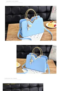 Détail du sac à main bleu clair avec texture géométrique et cadre métallique doré en forme de M