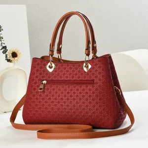 Detail of red woven texture shoulder bag with brown handle and golden hardware zipper