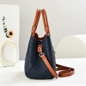 Close-up of blue woven texture pattern and brown leather handle with gold hardware