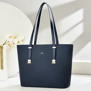 Close-up of navy blue tote bag featuring diamond texture and golden hardware