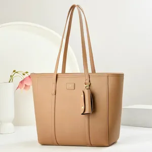 Detail einer hellbraunen Tragetasche aus genarbtem Leder mit passender kleiner Tasche