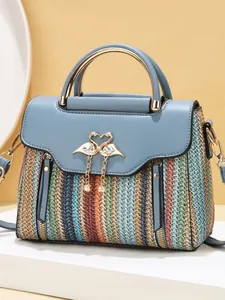 Striped crossbody bag with gold metal handle, pearl charm and blue textured finish