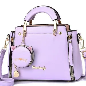 Light purple faux leather tote bag with gold logo, cat charm, and adjustable strap
