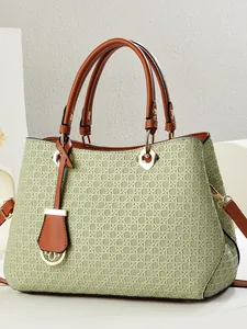 Sage green woven shoulder bag with brown leather trim and golden hardware details