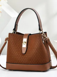 Brown leather bucket bag featuring a V-shaped woven texture and golden clasp detail