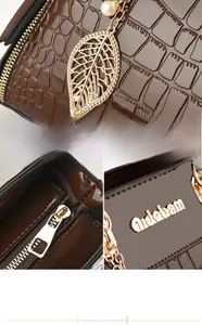 Detailed view of brown embossed crocodile leather handbag with golden leaf and pearl accents