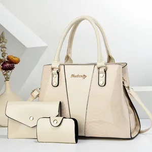 Detail view of snakeskin pattern leather on white three-piece fashion handbag set