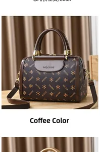Detail of coffee brown Boston bag featuring textured MQCKDE monogram and gold hardware
