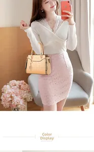 Beige tote bag with crocodile pattern and leaf pendant on white lace dress
