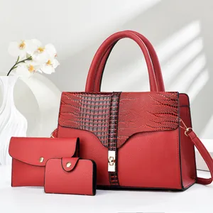 Macro shot of red pebble leather tote bag with crocodile texture and gold metal buckle