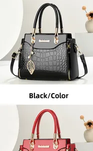 Close-up of embossed crocodile pattern handbags with leaf pendants in black and red