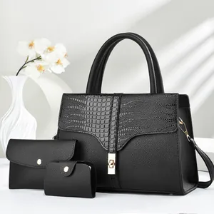 Detailed macro view of black crocodile pattern faux leather handbag with gold twist lock