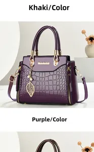 Detail of embossed crocodile texture and gold hardware on purple leather tote bag