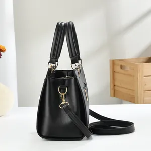 Close-up of black crossbody bag showing cross-grain leather texture and gold hardware